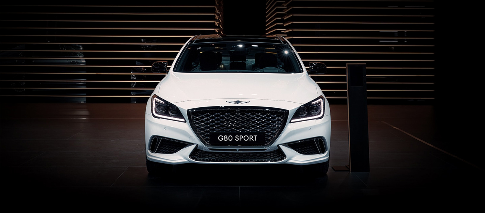 Genesis G80 sport white front profile in showroom 