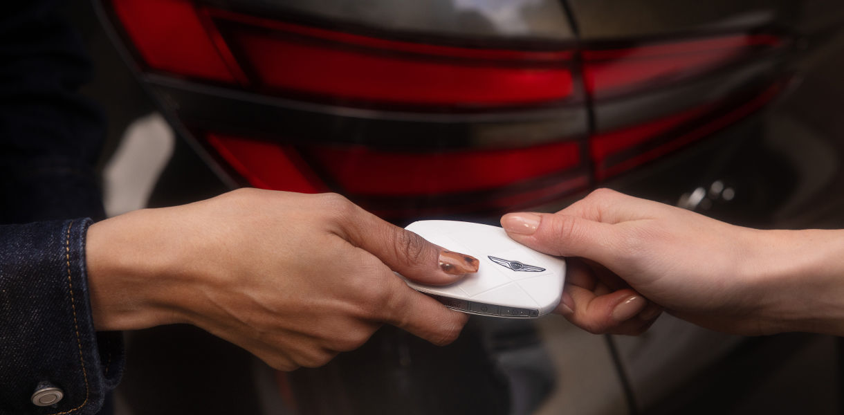 Two people handing keys to each other 