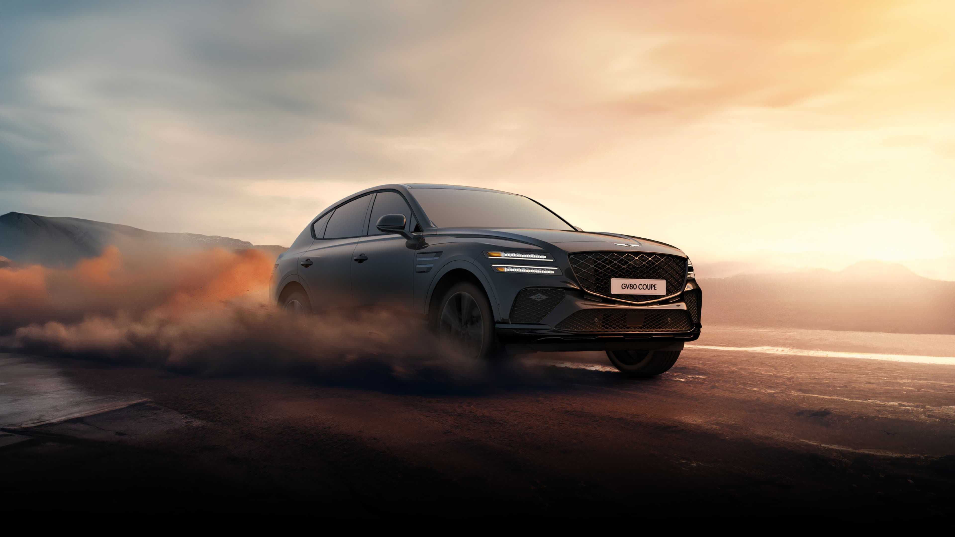 GV80 Coupe in Vik Black driving on a sandy beach.