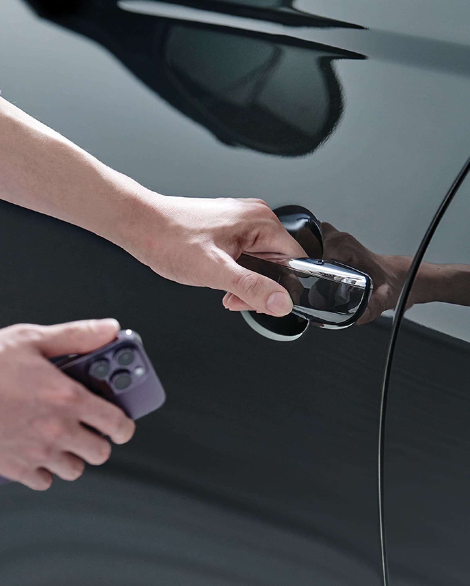 The driver is seen holding a smartphone close to the vehicle door.