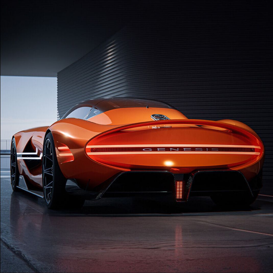 The X Gran Berlinetta Concept is parked indoors, showcasing its rear view as it faces the exit. The sleek, elongated oval shape and contoured body are prominently displayed, emphasizing its sophisticated design.