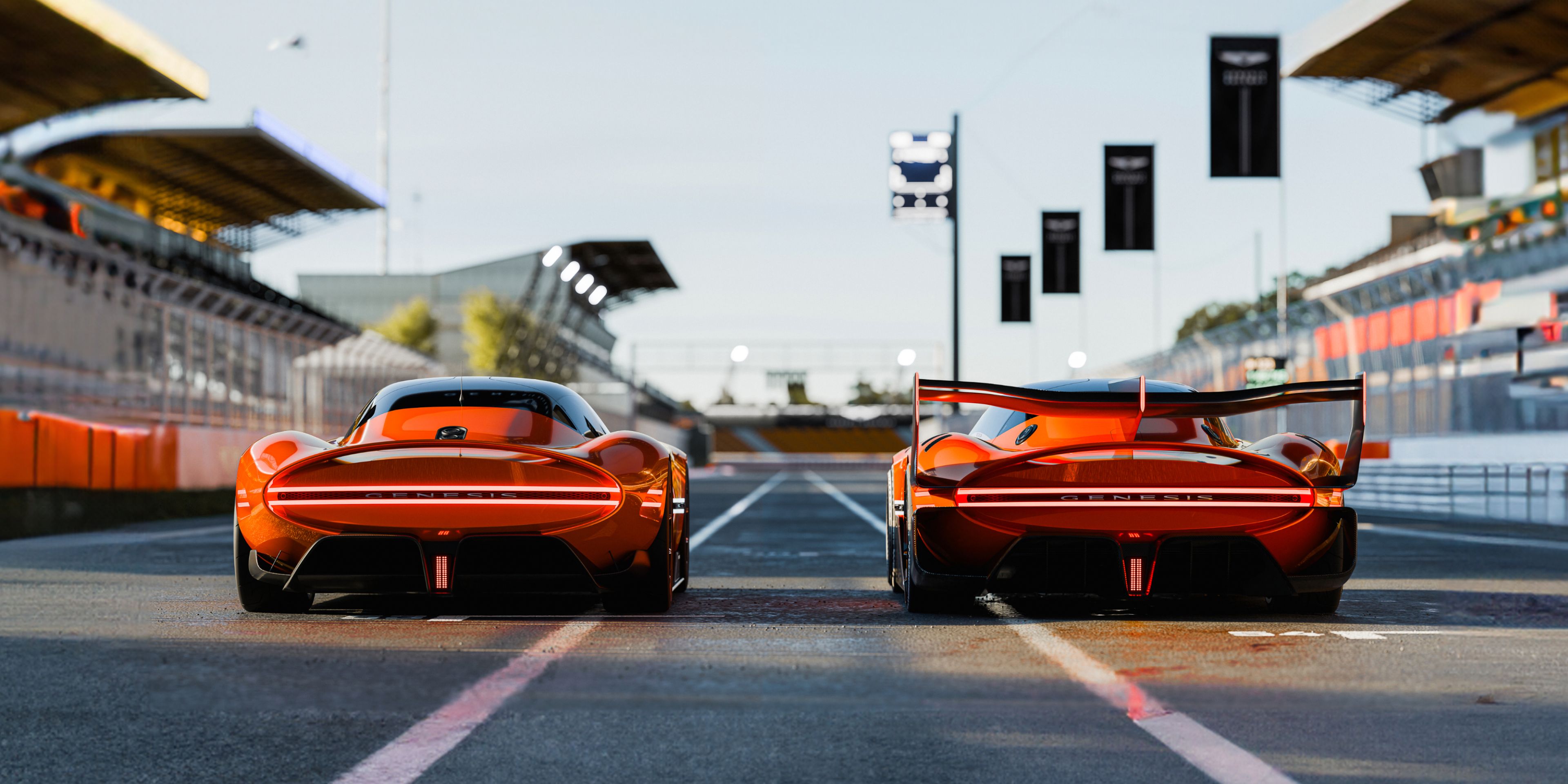 Genesis X Gran Berlinetta Concept and Genesis X Gran Racer Concept are parked side-by-side on a race track, ready to race one another.