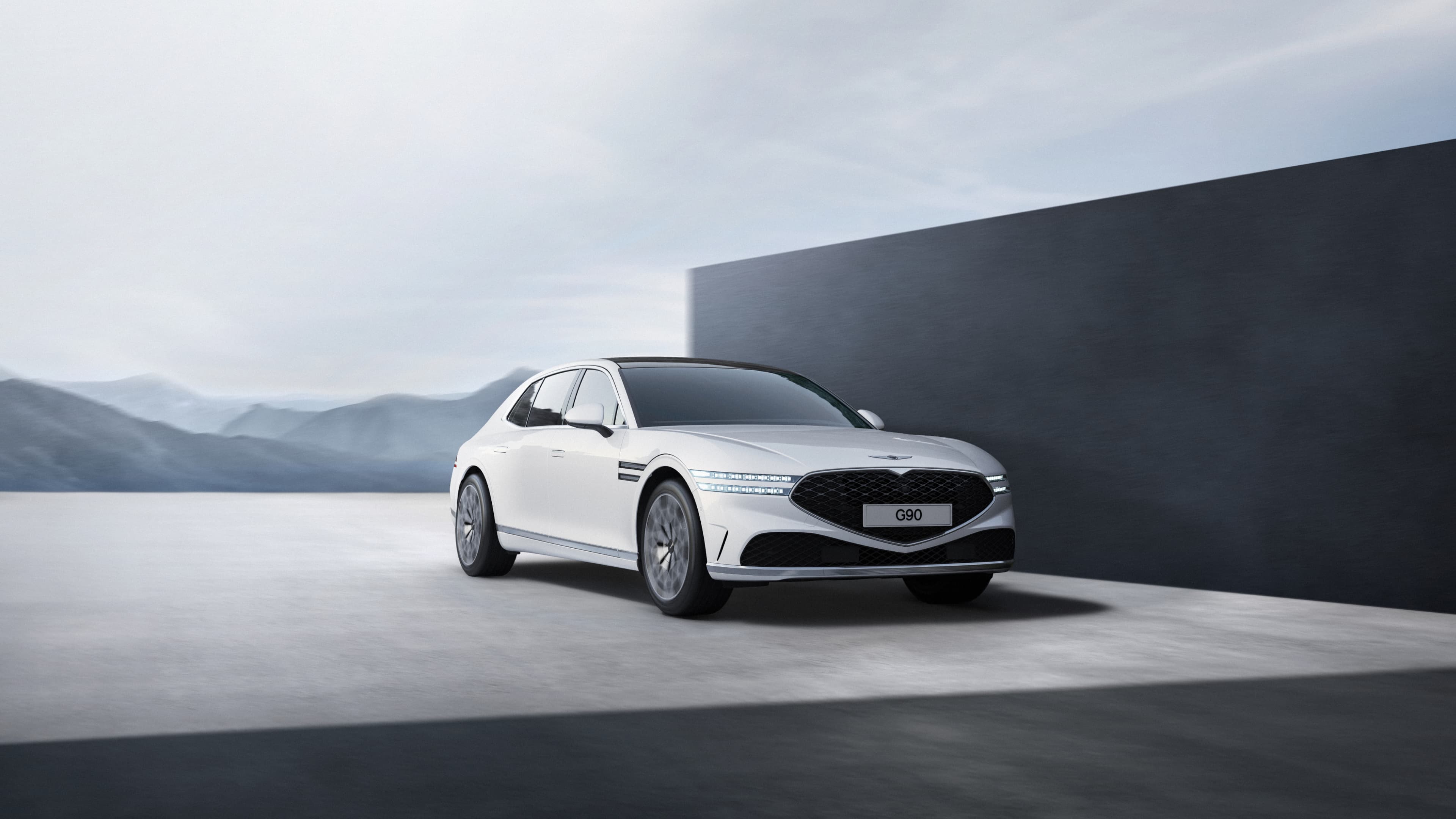 The front end of Uyuni White G90 driving next to a gray wall.