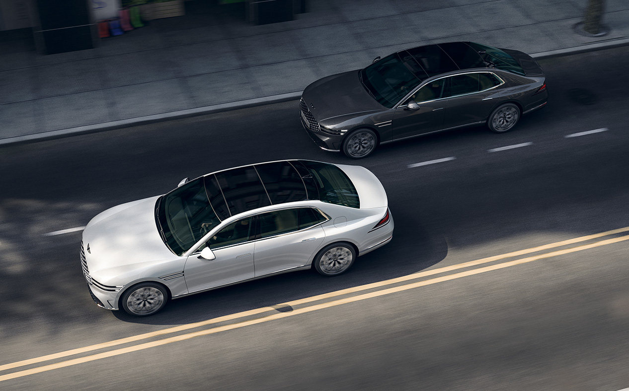 A G90 in Uyuni White and a G90 in Makalu Gray are driving.