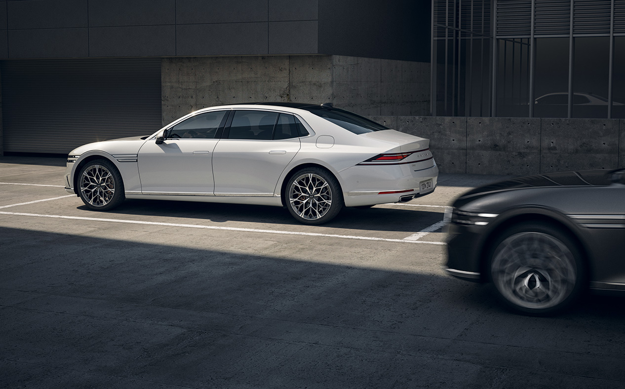 Uyuni White G90 is parked and with Maui Black G90 driving next to it.