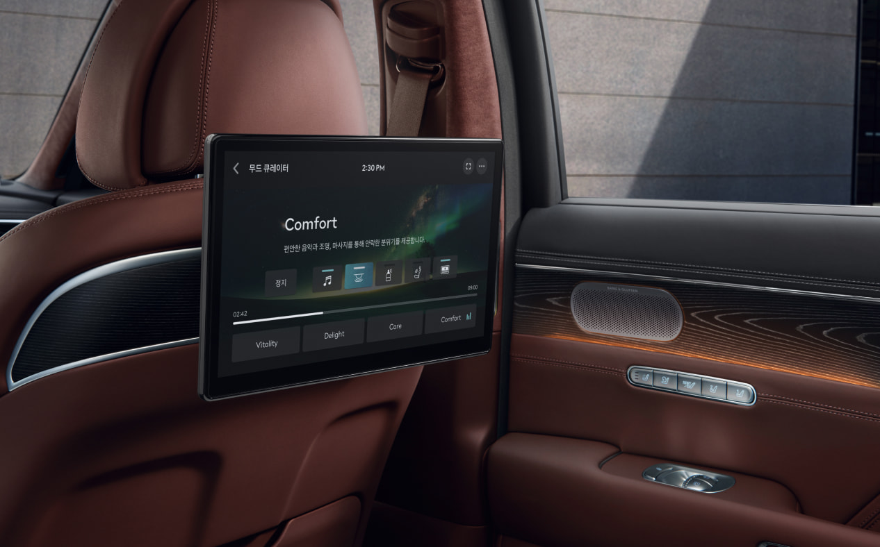 Orange lights are illuminated on the second row dual monitors and the vehicle door inside Bordeaux Brown interior.