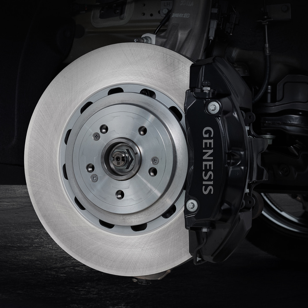 Inside the wheel, a black brake caliper engraved with 'GENESIS' is visible.