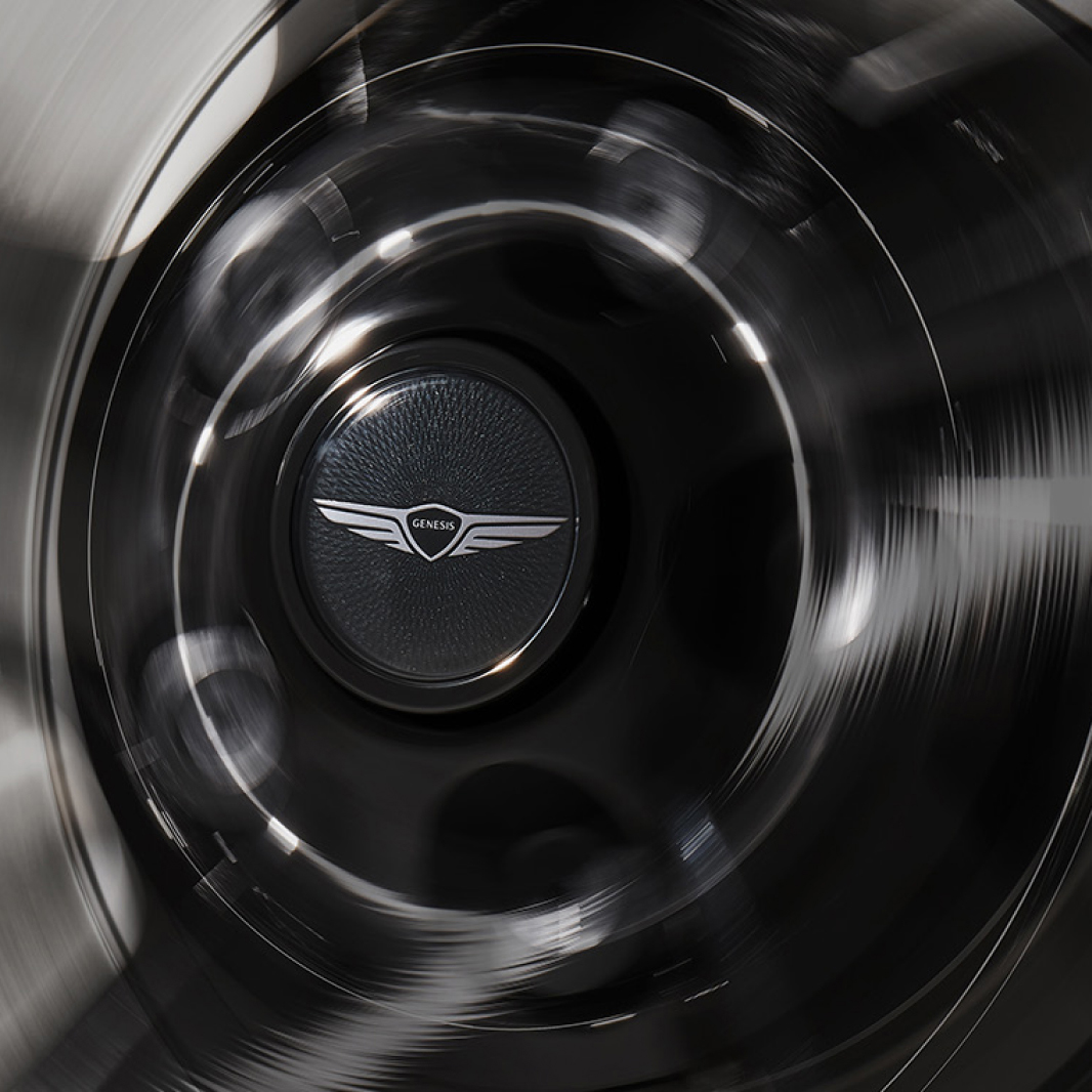 The spinning wheel cap displays a black floating Genesis emblem.