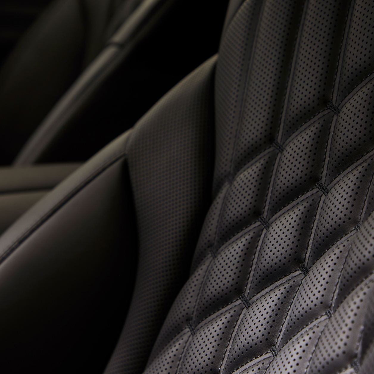 The quilted pattern of the black seats is emphasized.