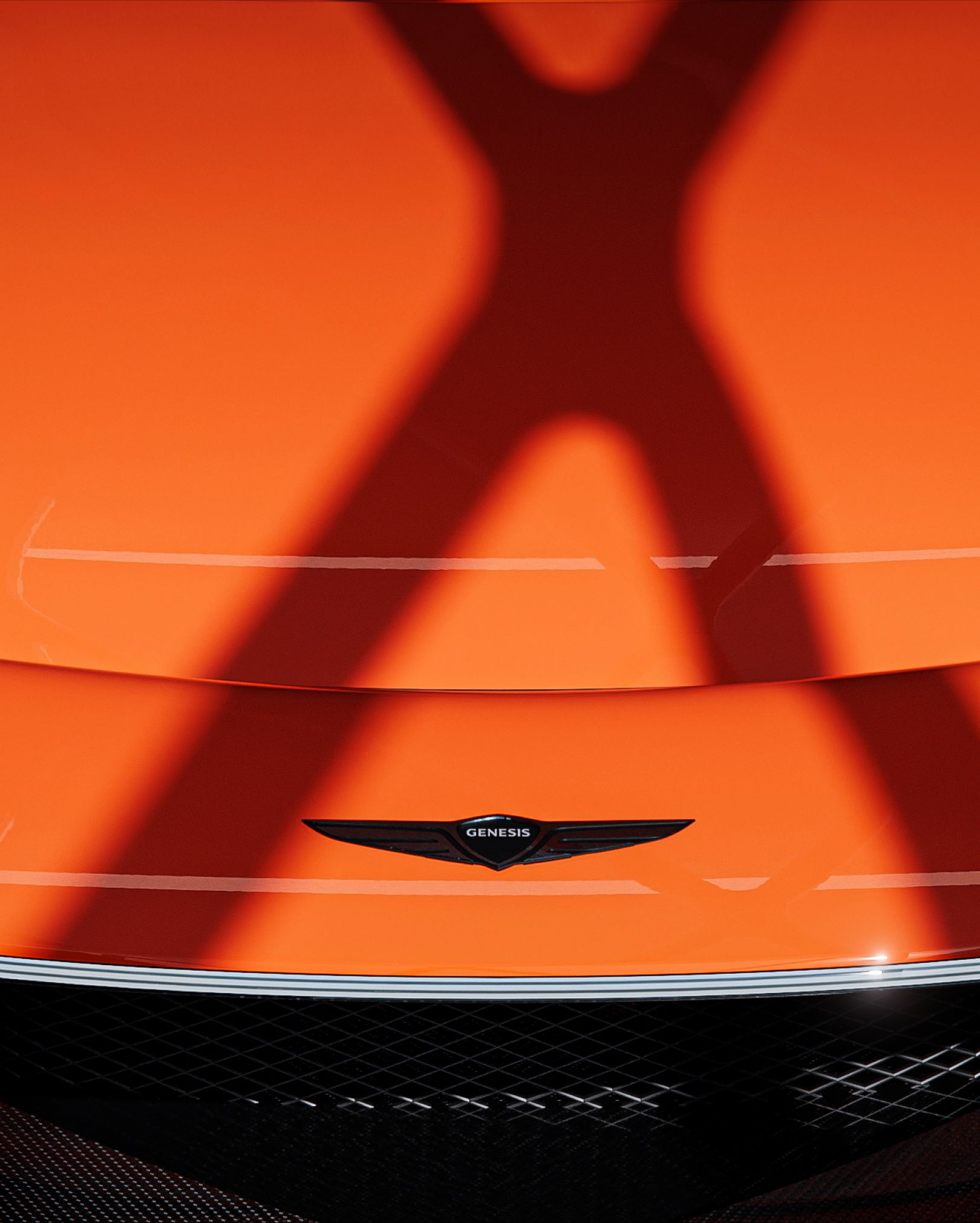 An intense shadow of an 'X' is cast over the vibrant orange hood of the X Gran Berlinetta Concept.