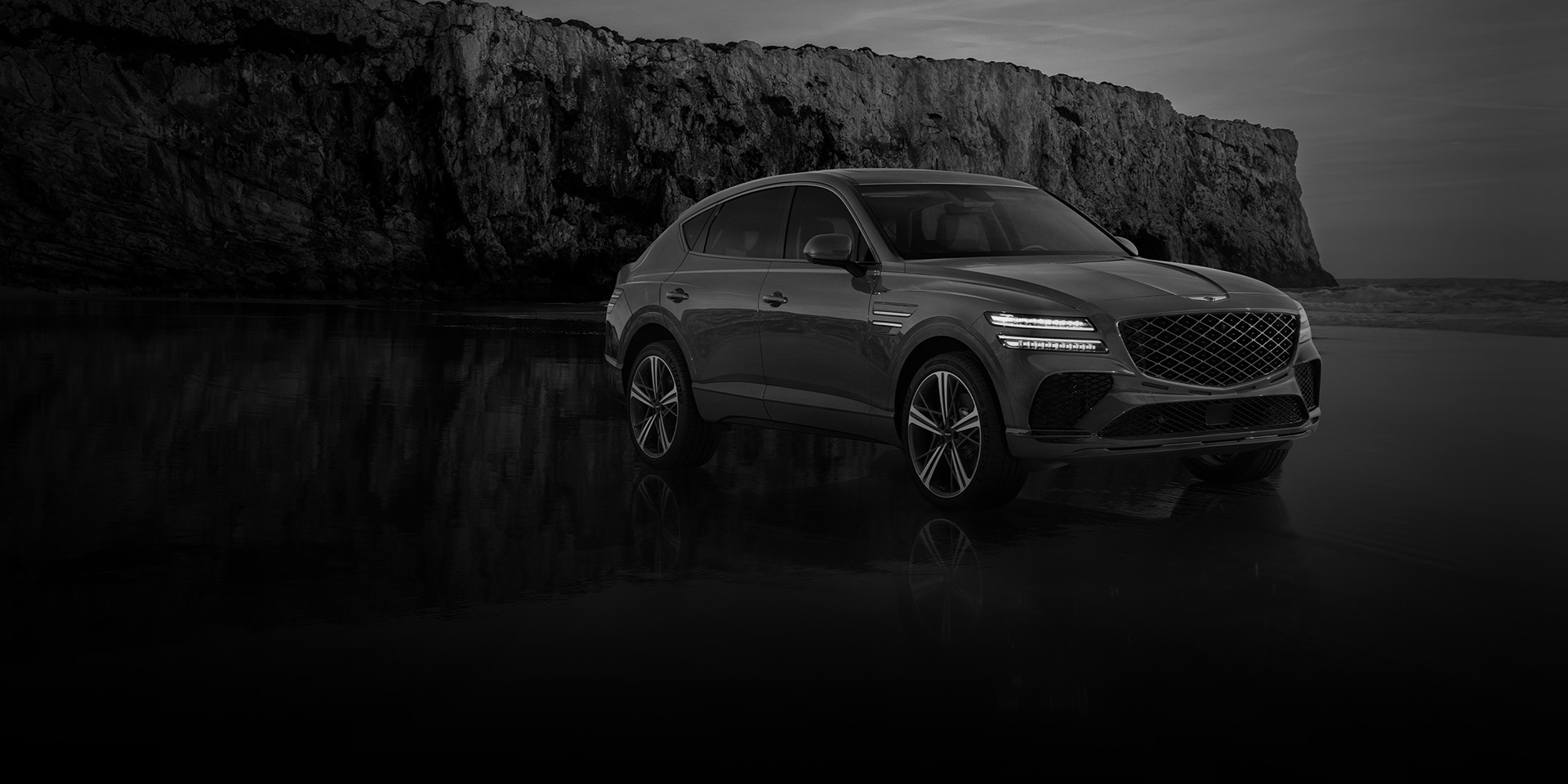 GV80 Coupe parked in front of the rock wall.