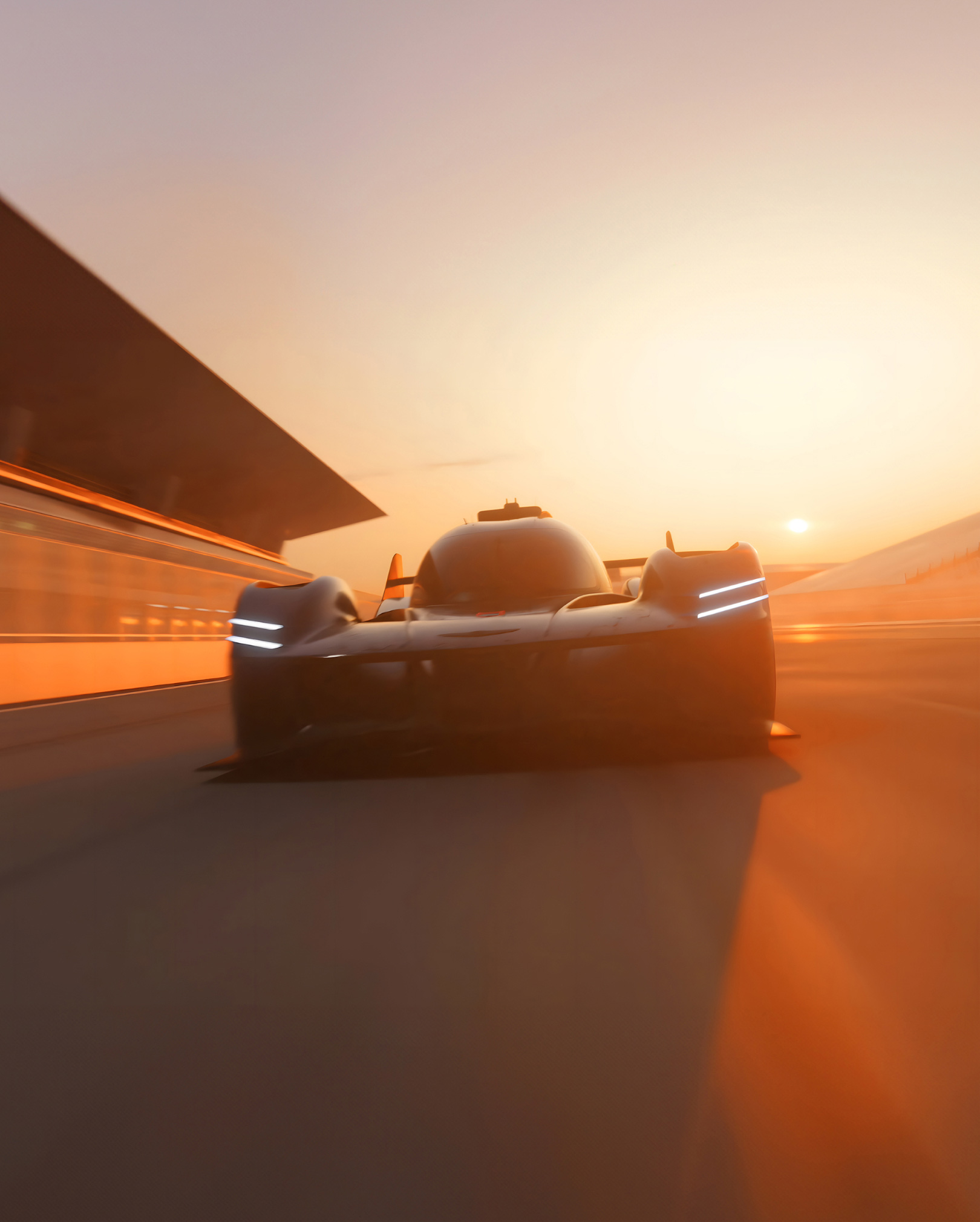 The GMR-001 Hypercar races through a racetrack during dawn, painting the overall backdrop orange.