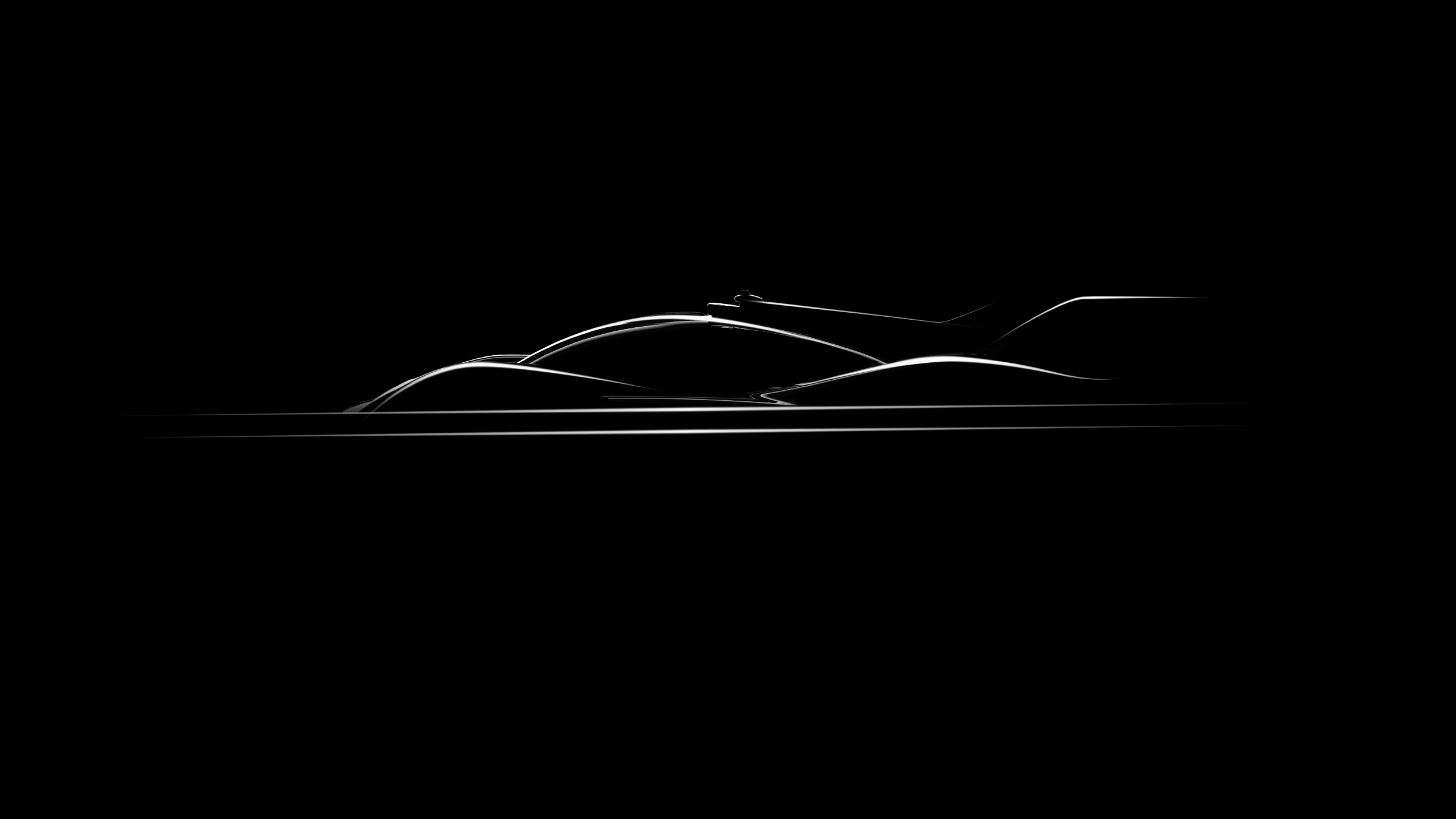 Against a dark background, a Genesis Magma lineup vehicle shines, revealing its sleek silhouette.