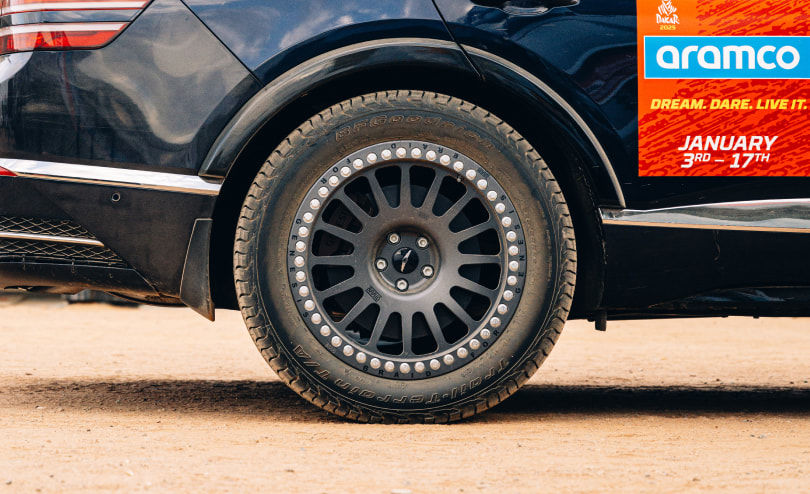 It shows off the giant wheels of the Genesis GV80 Desert Edition Concept. Strong tires suitable for off-road driving have desert sand on them.