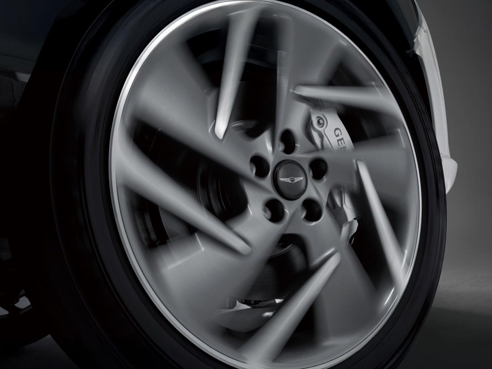  A floating wheel cap with the Genesis emblem can be seen in the middle of the rotating wheel.