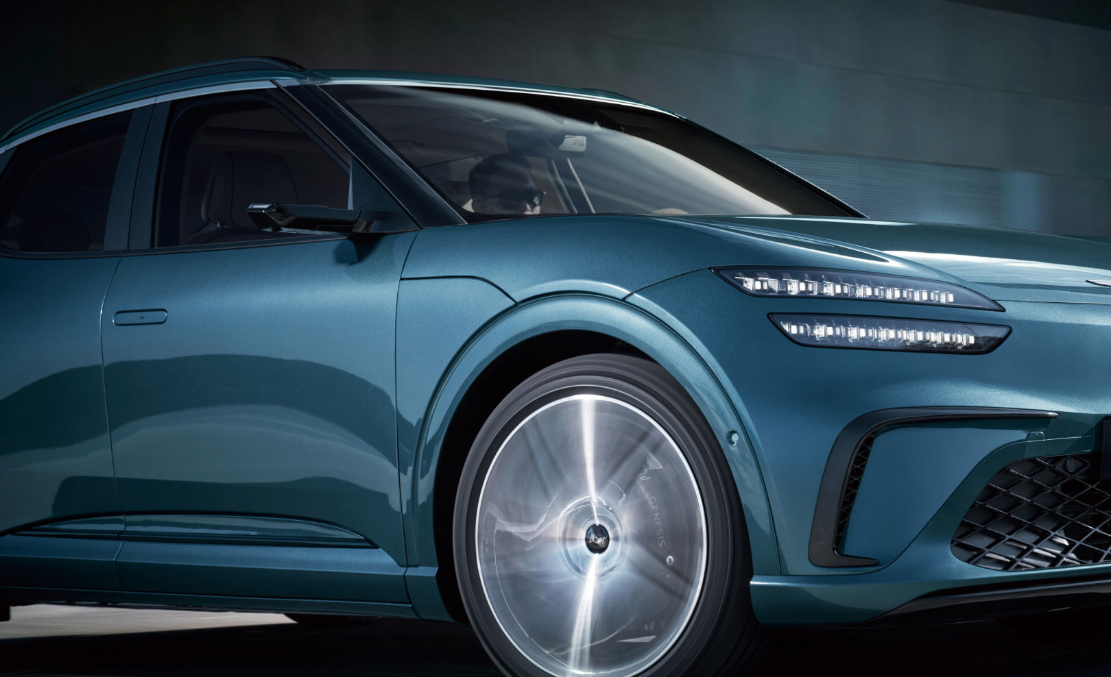  The front wheels of the fast-driving GV60 vehicle are enlarged. You can see the wheel spinning.