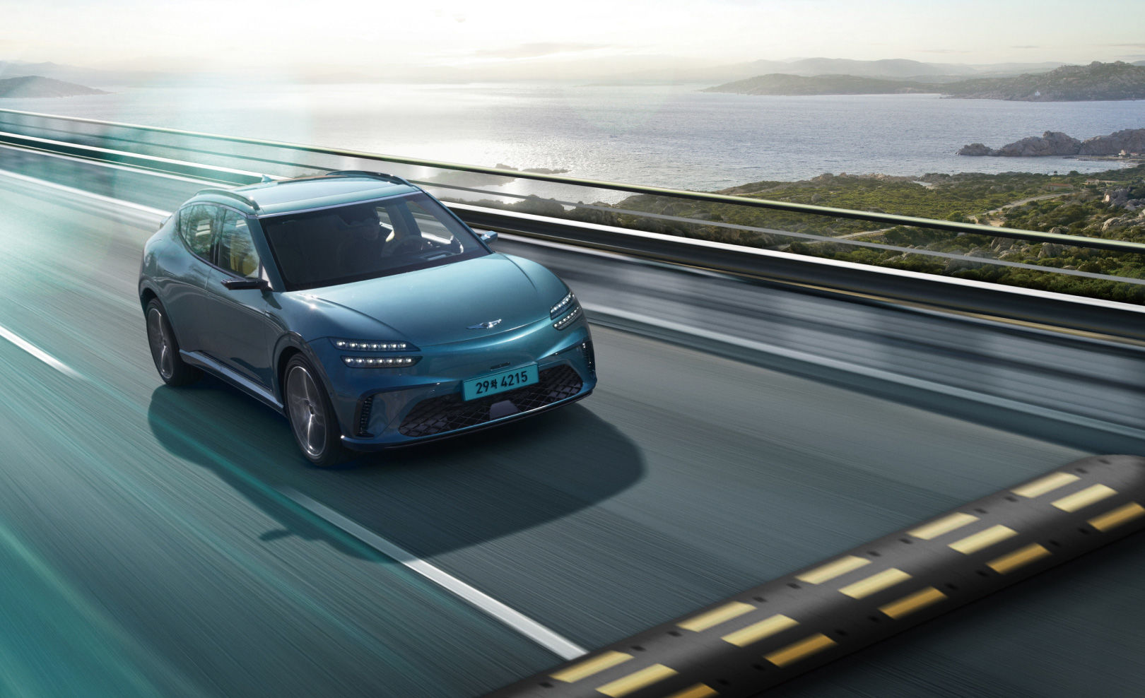  The GV60 vehicle is driving quickly on the road with the natural scenery of the sea and islands in the background. You will see a bump right in front of you.