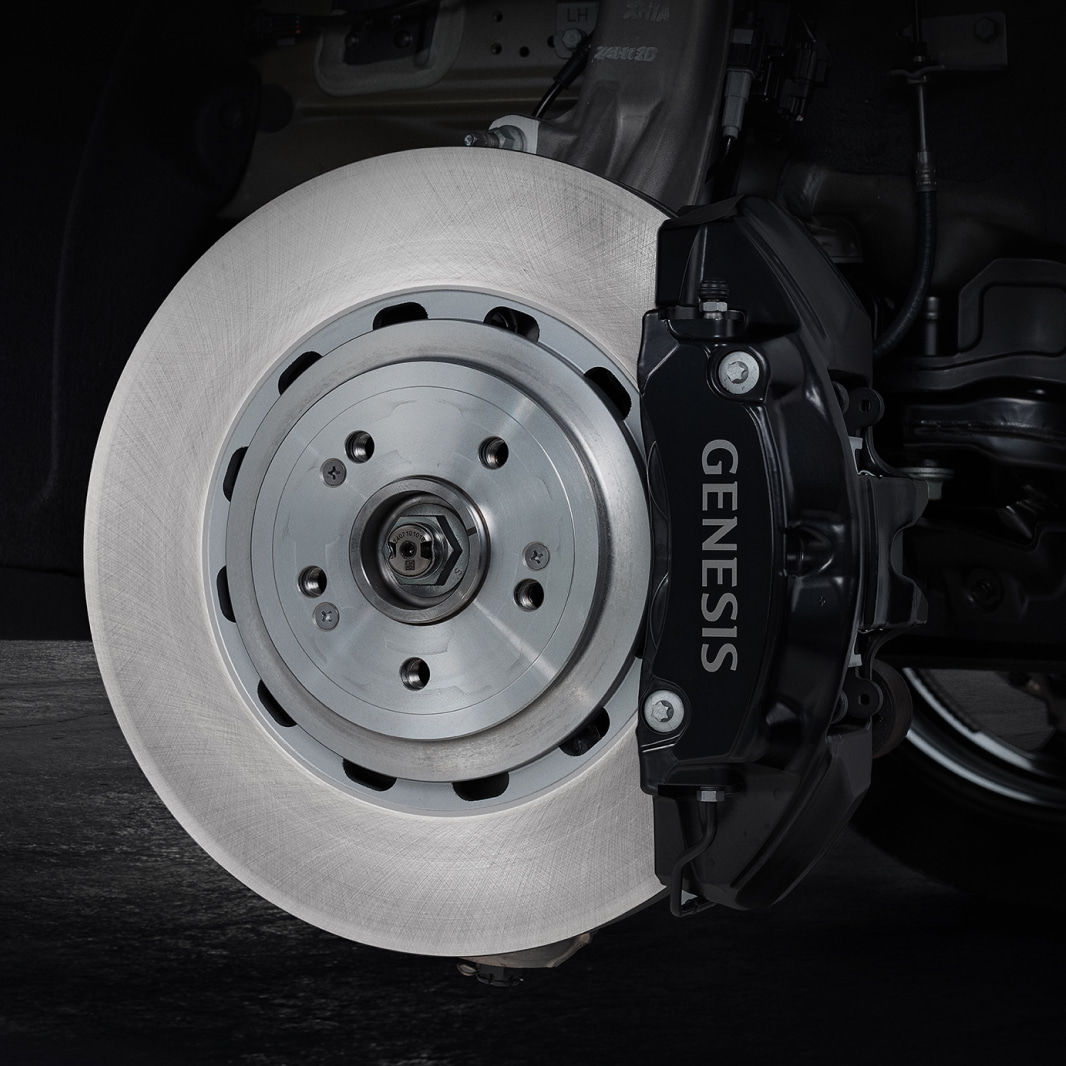 Inside the wheel, a black brake caliper engraved with 'GENESIS' is visible.