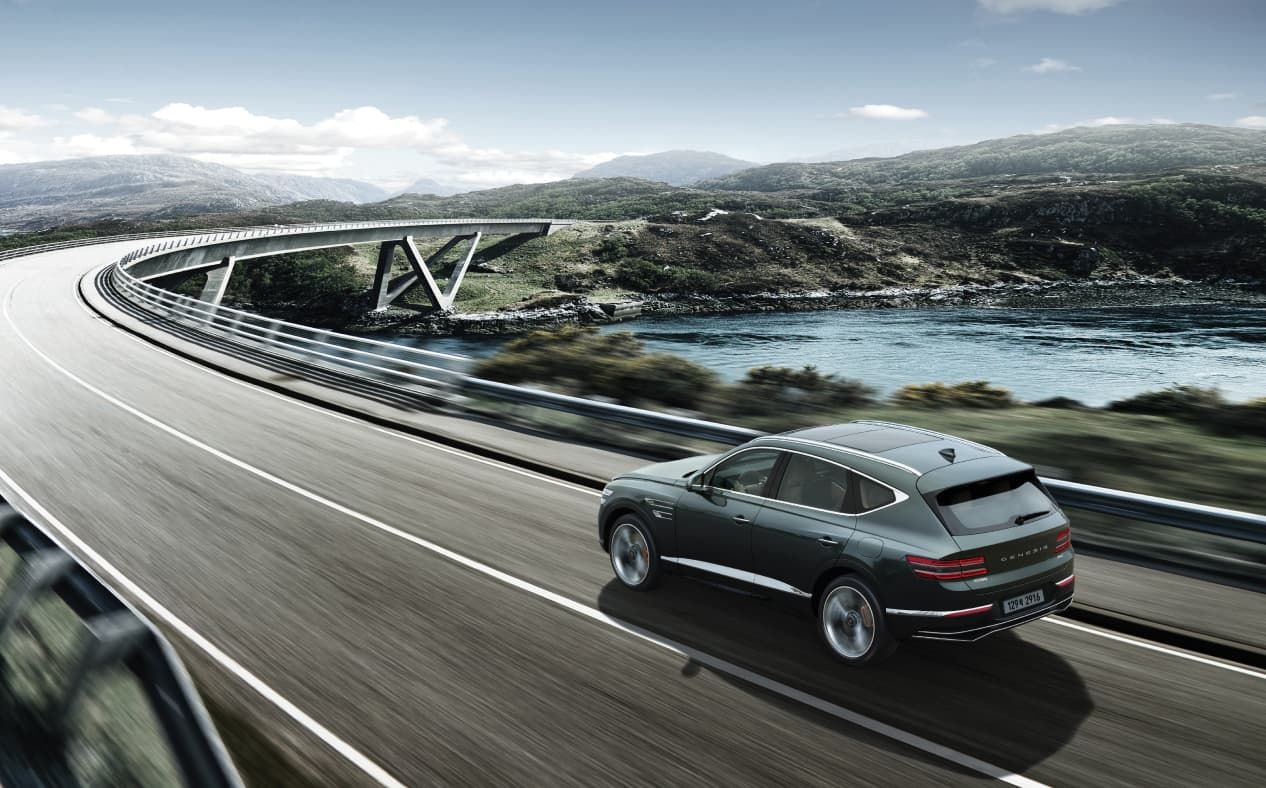 Storr Green GV80 driving fast on the highway while maintaining a safe distance from the vehicle in front.